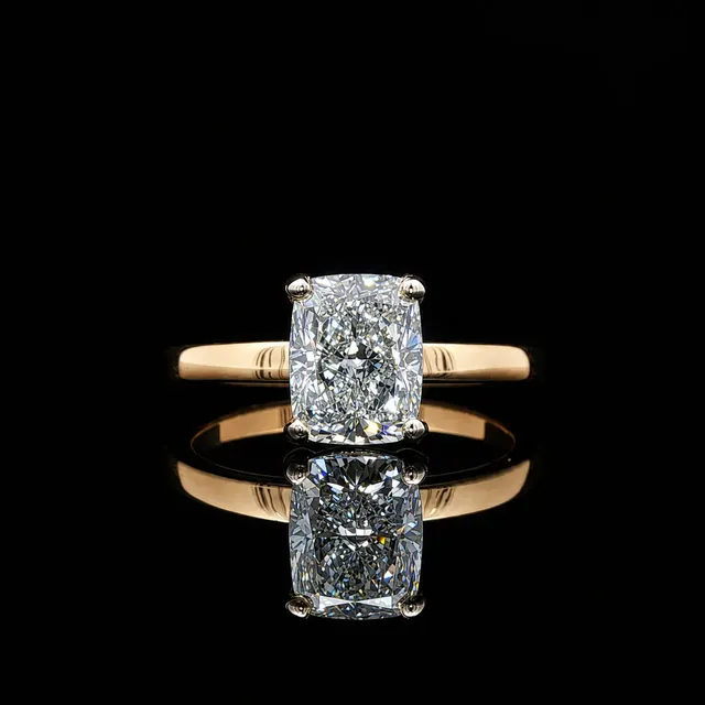 A cushion cut diamond solitaire on a yellow gold band