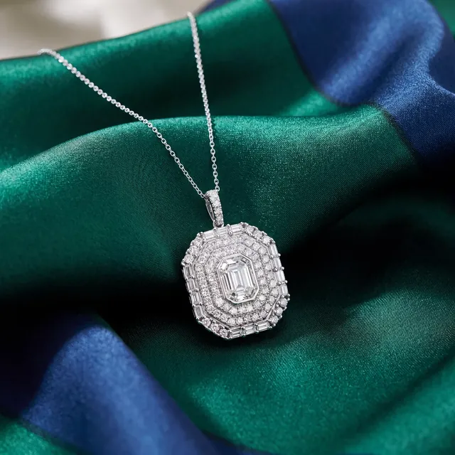 A white gold diamond pendant on green and blue silk