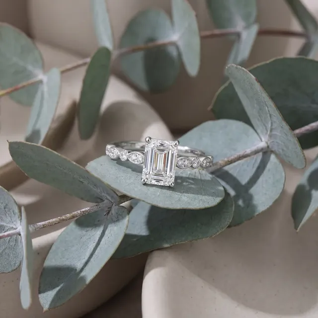 A white gold emerald cut diamond ring on eucalyptus
