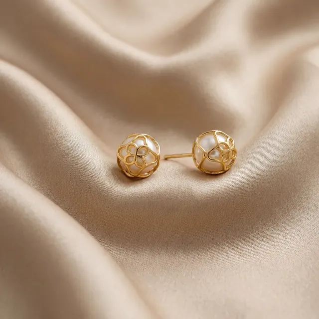 Textured yellow gold ball studs on cream satin