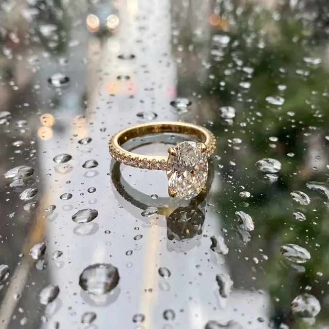 A yellow gold cushion diamond ring among water drops