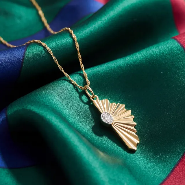 A gold fan pendant on green and blue silk