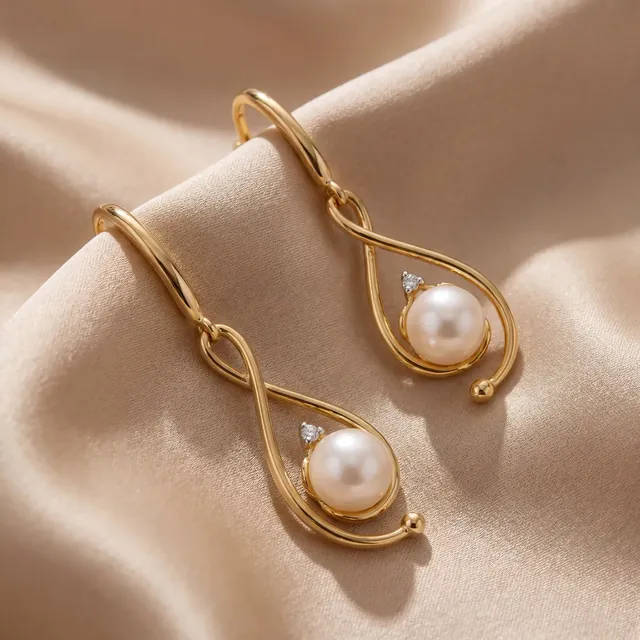 Gold swirl earrings with pearls on cream satin