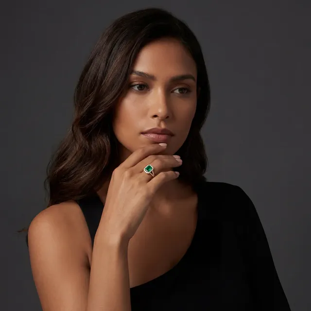 A woman in black wearing an emerald ring