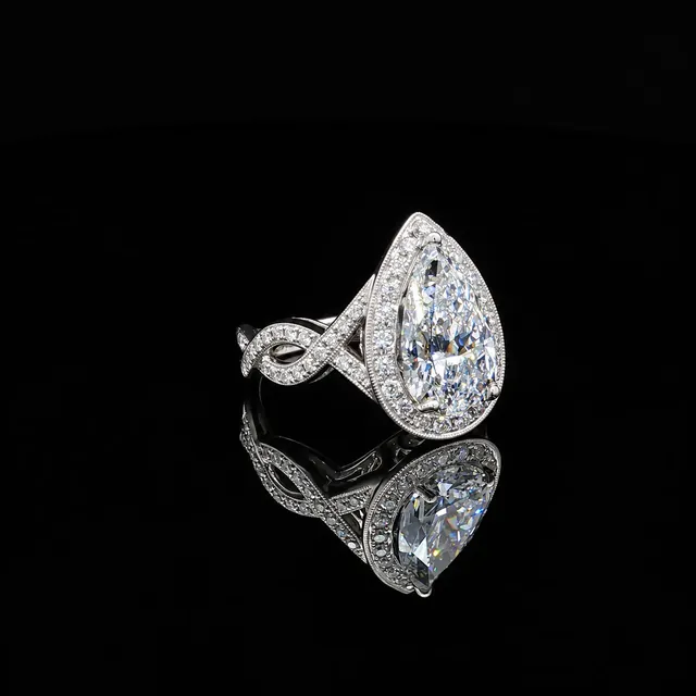 A white gold pear diamond halo ring on black