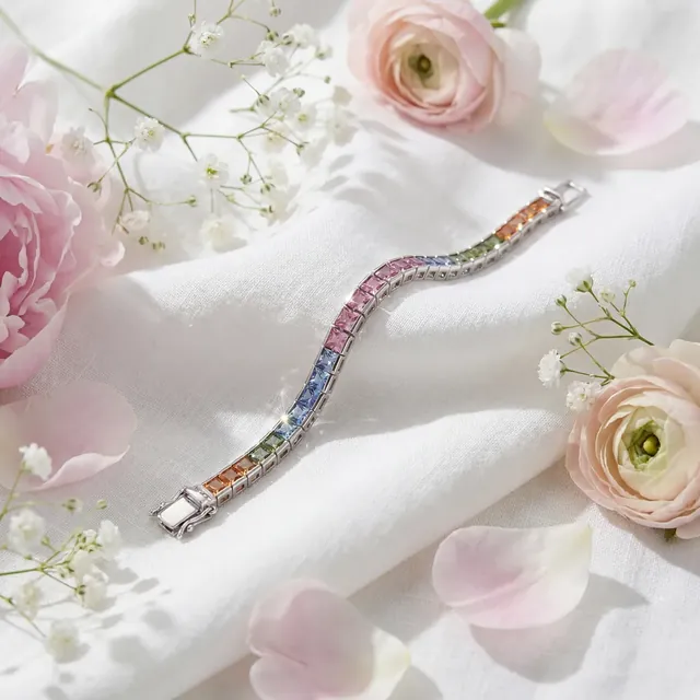 A rainbow gemstone line bracelet on white cloth among flowers