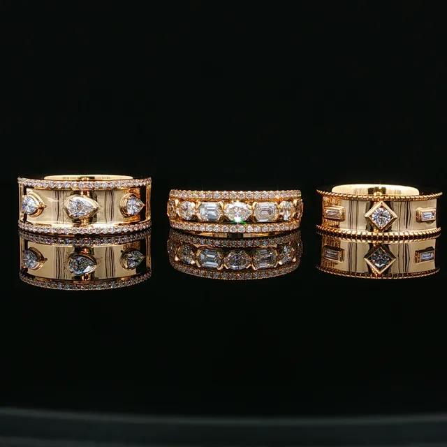 Three wide yellow gold bands set with diamonds on black